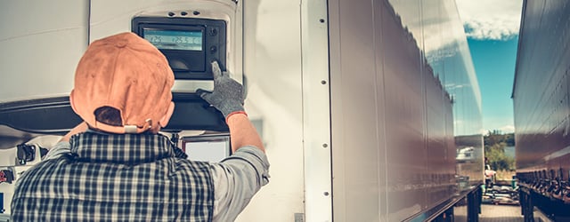 worker pushing buttons on a cold chain truck