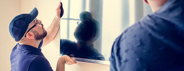 two people mounting a TV
